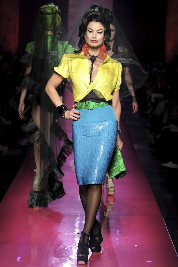 Jean Paul Gaultier SS2012 Couture。Gaultier 成功地将他的高级时装发布变成了Amy Winehouse的欢送会，并为他美丽而怪异的服装增添了色彩艳丽的一笔。并且Gaultier 设计的用披肩包住一边的细条纹西装夹克、珠饰细腿…