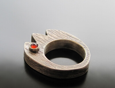 Hollow form, sterling silver tulip ring, featuring a bezel set garnet faceted cabochon.