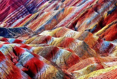 张掖丹霞地貌，中国 张掖丹霞地貌位于甘肃省河西走廊中段的张掖市，地貌发育于距今约200万年的前侏罗纪至第三纪。方圆一百万平方内，数以千计的悬崖山峦呈现出彩虹般的斑斓色彩，在阳光映衬下，让人不得不赞叹大自然的鬼斧神工。