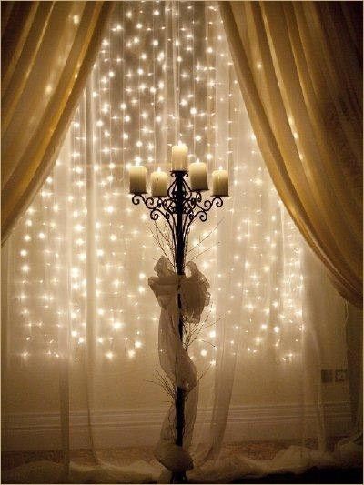 Strings of mini lights attached to a rod behind sheer fabric. Love this idea for the holidays.