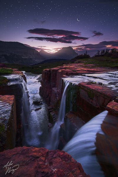 Morning twilight and a rising moon over Glacier National Park's Triple Falls, Montana