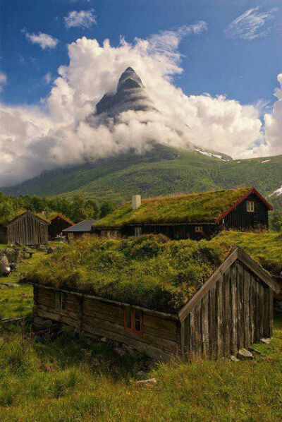 The mountain in the background is lost in the clouds and creates an aura in the picture. While the grass on the roofs of the building create a natural feeling