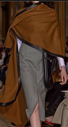 Hermès, Fall 2013: Flowing cape in tobacco colored cashmere with leather trim over a crisp white shirt; greige pencil skirt; large bandolier with attached pochette ~ Hermès Paris