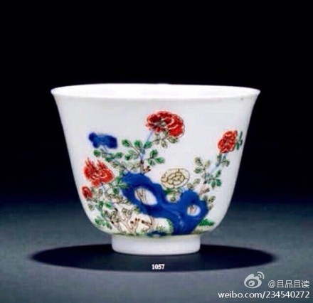 清康熙【五彩花神杯】高7 cm厘米。本品口微撇，深弧腹，下承圈足。制作规整，器形秀美，胎薄体轻， 胎质洁白紧致，釉色莹润，外壁绘牡丹图一幅，是为四月之花神，其以青花绘洞石，生出牡丹花朵一丛，青花之上又以绿彩绘叶，以淡赭彩绘枝桠，以红彩、黄彩绘花朵，纵观红花四枝，黄花一枝，青花花卉一枝