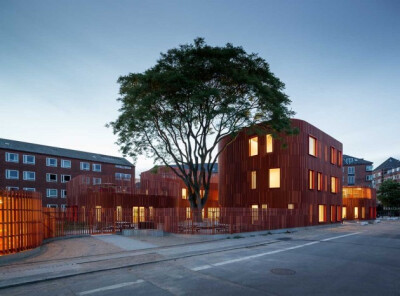 #品.创意#丹麦建筑师COBE完成一个新的日托中心在哥本哈根与弯曲的角落，郁郁葱葱的屋顶花园和一个特殊的砖立面，给出了建立一个温暖的现代感，同时体现出其历史环境。