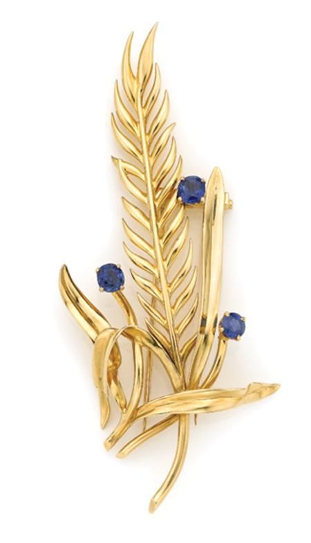 Gold and Sapphire Clip, Van Cleef &amp;amp; Arpels 18 kt., the stylized leaf brooch centering one long detailed leaf atop polished gold leaves, accented by 3 round sapphires approximately 2.50 cts., signed VCA for Van Cleef &amp;amp; Arpels, NY, # 637, circa 1950, approximately 15.8 dwt.