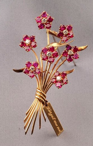 Ruby and Diamond Forget-me-not Brooch, Van Cleef &amp;amp; Arpels, 1941, designed as five ruby melee blossoms centered by diamonds, stems bound by an inscribed card, gold mount, 2 3/8 x 1 3/4 in., no. 1113.