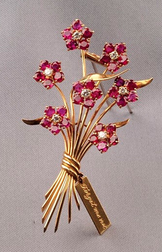 Ruby and Diamond Forget-me-not Brooch, Van Cleef &amp;amp; Arpels, 1941, designed as five ruby melee blossoms centered by diamonds, stems bound by an inscribed card, gold mount, 2 3/8 x 1 3/4 in., no.…