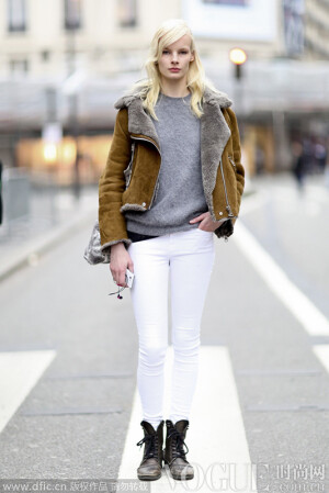 土黄色翻领外套搭配灰色毛绒上衣，下身身穿白色长裤，搭配复古绑带靴，时尚摩登，让人眼前一亮。