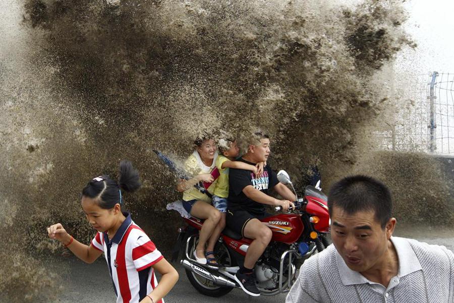 8月13日，中国浙江，壮观的钱塘江潮水涌上岸边，观潮人四散惊逃。