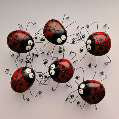 Cute idea..... Stones painted like lady bugs and strong bent wire for feet