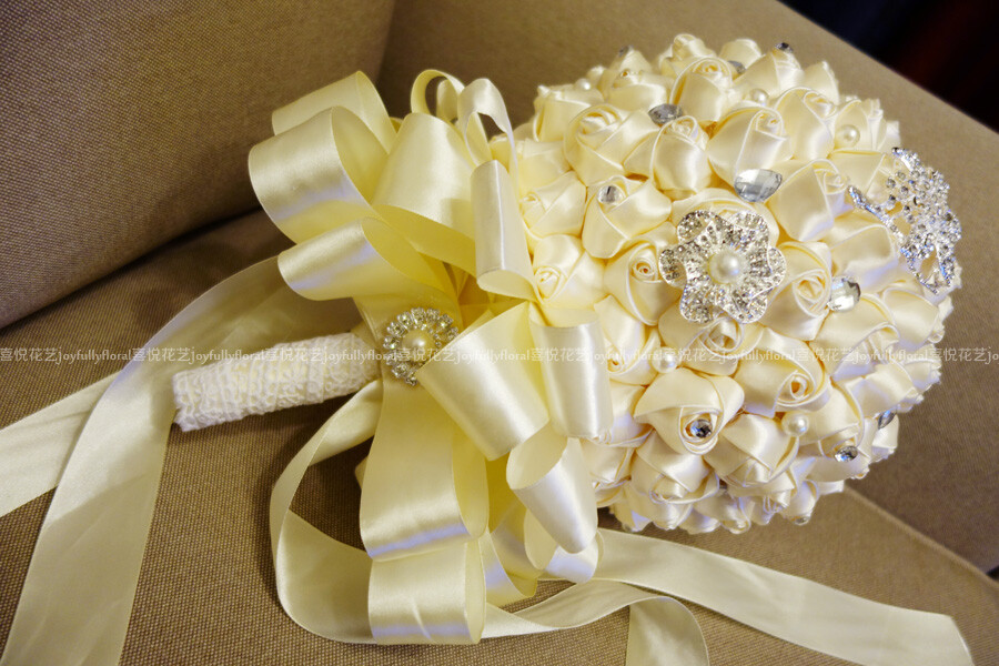奶白色的缎带新娘手捧花，水钻和珍珠配饰