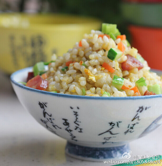  【金裹银蛋炒饭】1.胡萝卜黄瓜切小丁，腊肠切丁，小香葱择洗干净，切葱碎2.鸡蛋只取蛋黄，打散3.锅内放底油，先放腊肠丁炒出油份，然后加胡萝卜丁翻炒一下盛出来4.米饭放锅中铲子打散倒入蛋黄5.铲翻均匀6.加盐和少许白胡椒粉调味7.加腊肠丁，胡萝卜丁和黄瓜丁翻炒均匀，撒上小香葱炒匀。 @百味美食坊