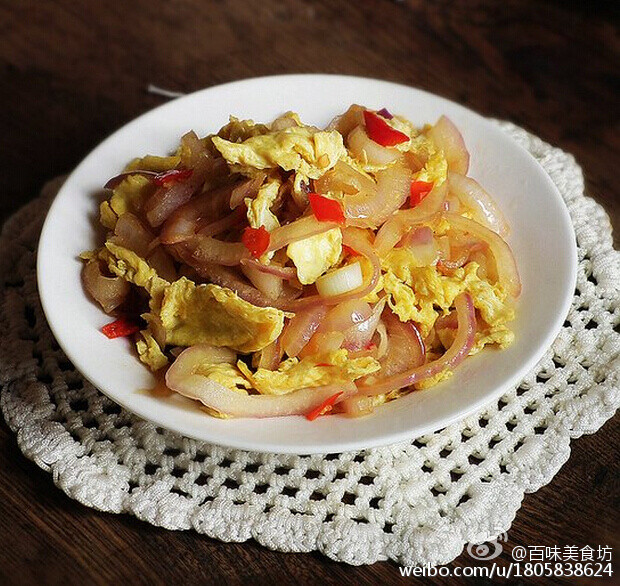  【洋葱炒蛋】1.把洋葱洗净，切成细条2.鸡蛋磕进碗中，加入适量的料酒打散3.锅中注油，烧热下入蛋液炒散盛出备用4.锅中留底油，加入泡椒5.倒入洋葱丝煸炒。煸炒至洋葱丝透明。 加入少量的酱油。煸炒均匀6.倒入炒好的鸡蛋，翻炒均匀加入盐调味即可。 @百味美食坊