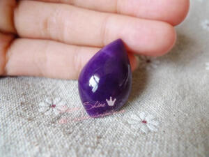 这枚舒俱来有着浓郁的皇家紫红色，上面撒着星星点点的星空式花纹，透着让人窒息的贵气与骄傲；形制则是十分特别的形状，介于柳叶形和水滴形之间，活泼的形制给端庄的皇家紫色添加了一丝生气，让整体感觉既贵气又不死板~