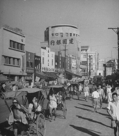 这是1944年重建的建国银行，有这个显著的地标，我们就可以知道，这里就是今天民族路往朝天门方向十字路口的小广场所在的位置——民族路2号。 我是重庆，这是我3、40年代的照片！