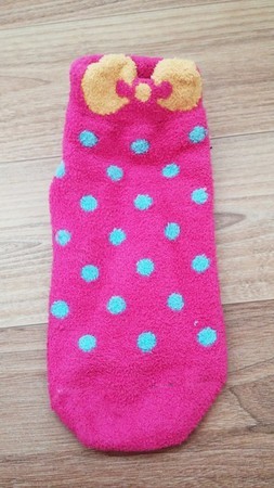 6、如果嫌太单调的话，可以再从别的袜子上剪下一些图案装饰，像是这个粉红袜子上的蝴蝶结，剪下后修整