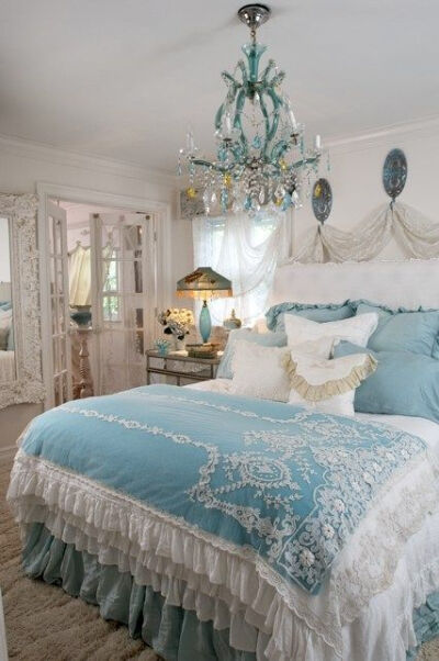 Yummy! Pure romance. Bedspread with lace appliques, tons of ruffles, a mound of cushions, and a delightful aqua and clear crystal chandelier are some of the highlights of this Shabby Cottage Chic bedr…