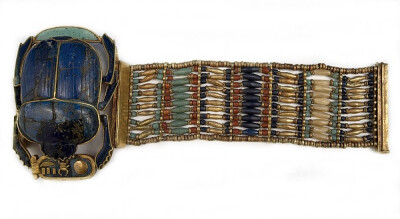 【图坦卡蒙腕带】Flexible Bracelet of king Tutankhamun 金、蓝色玻璃、天青石、方解石珠子串成，可以柔软绕在手腕上。手镯一端的大圣甲虫，在佩戴时会出现在手腕中央作为主要装饰。