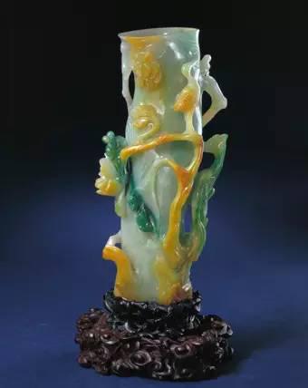 翠花鸟花插，清，高25厘米，口径5.9×8厘米。 翠呈青绿色，局部有深绿及黄褐色?；ú褰细?，呈树桩形，主杆粗大，内可插物?；ú宓耐獗陲蔚衲档せㄖ?，枝上立着禽鸟。下配以镂空雕花红木座。 花插属陈设用品，内可插物。明代玉器中已有花插，多呈筒状。清代的玉花插样式较多，其中树桩形花插较为典型。这件花插所用翠料有较高的透明度，局部绿色深重，属高档材料，是清代宫廷的重要陈设器。