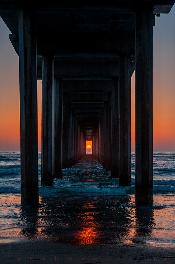 加州的斯科普利斯栈桥（Scripps pier），每年只有两次机会能捕捉到这一时刻，太阳和所有桥墩完美呈一条直线，摄影师John H. Moore拍下了这一幕