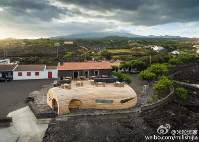 餐厅扩建是不少建筑事务所面临的课题，这家位于葡萄牙亚速尔群岛（ Azores ）中的皮库(Pico)岛上带酒吧的餐厅，原本只有一个火山岩墙面的老房子，来自葡萄牙的 FCC 建筑事务所的设计师直接在外面加了一个木……桶。