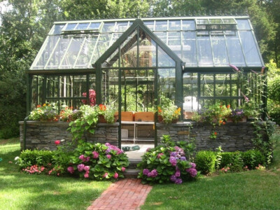 This is a lovely high-end greenhouse with a strong foundation and sturdy construction. This greenhouse is surrounded by wonderful landscaping to make the building very appealing.