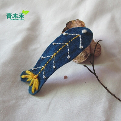 可爱的刺绣小鱼仔仔戴在头上。