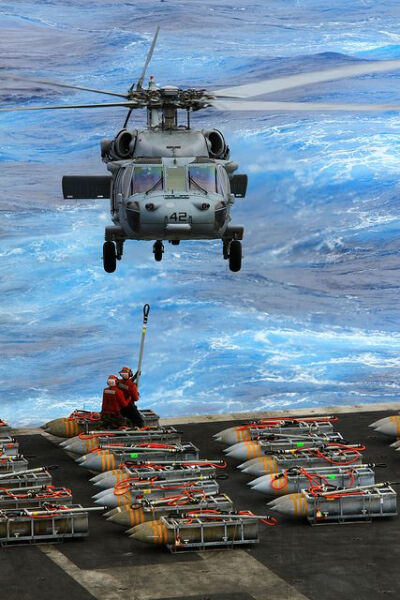 An MH-60S picks up ammunition. by Official U.S. Navy Imagery: