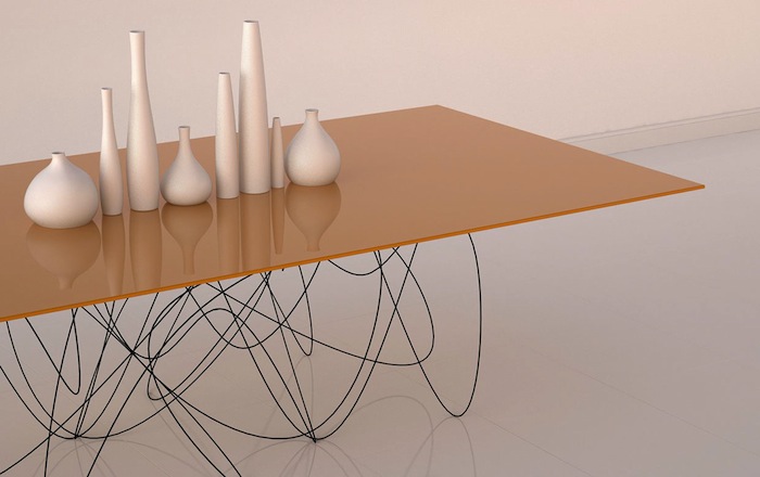 美国设计师 Jason Phillips 带来的「量子餐桌＼Quantum Table」设计，通过看上去细微而潦乱的独特桌腿， Jason 向我们解释了亚原子粒子的运动和路径可能的样貌。餐桌表面由喷涂了橙色漆的可丽耐材料制作，底部则是大口径钢线手工成形，然后喷涂黑色，看似瘦弱、实则坚韧。