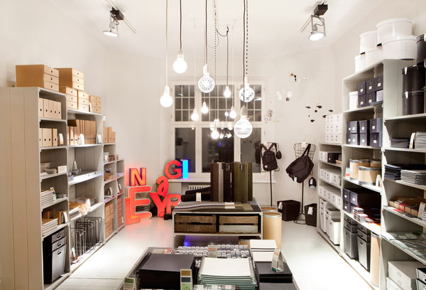 PINO 生活用品店品牌形象及店面设计，来自芬兰工作室 bond-agency。 店铺名称 “PINO” 在芬兰语中意为“成堆”或“堆放”，这个创意同样延续到店内置物架形式的设计中。这个90平米的店面位于一座古老的 Jugend 风格建筑中，为了顺应品牌未来的发展，店面内部设计必须是灵活，简单的，可以适应不同的场地面积。PINO 内部空间和置物系统都采用冷灰色调，地面则采用古朴的陶瓷地砖。由于所出售物品的尺寸差异很大，置物系统也要随之变化，不同宽度和高度的置物柜形成一个有趣的轮廓，正像是堆放的感觉。店面布局很简单，中间采用低矮的置物架以确保视线开阔，在形象墙前放置较大的台面，用于收银和包装。