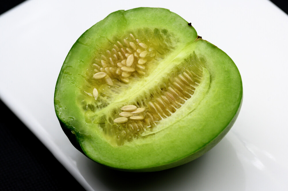 绿宝甜瓜 甜瓜 切开 黑色背景 白色瓷盘 水果 成熟 静物 蔬菜 食品