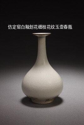 仿定窑白釉划花缠枝花纹玉壶春瓶。
清康熙，高14.2厘米，口径4厘米，足径5厘米。
瓶盘口，长颈，垂腹，圈足。
通体施白釉，釉面有细密的开片纹，口呈黑灰色，俗称“青灰口”，为仿宋代定窑瓷器所镶铜釦。
釉下划花装饰缠枝花卉，纹饰排列疏密有序，纹饰线条清晰流畅。