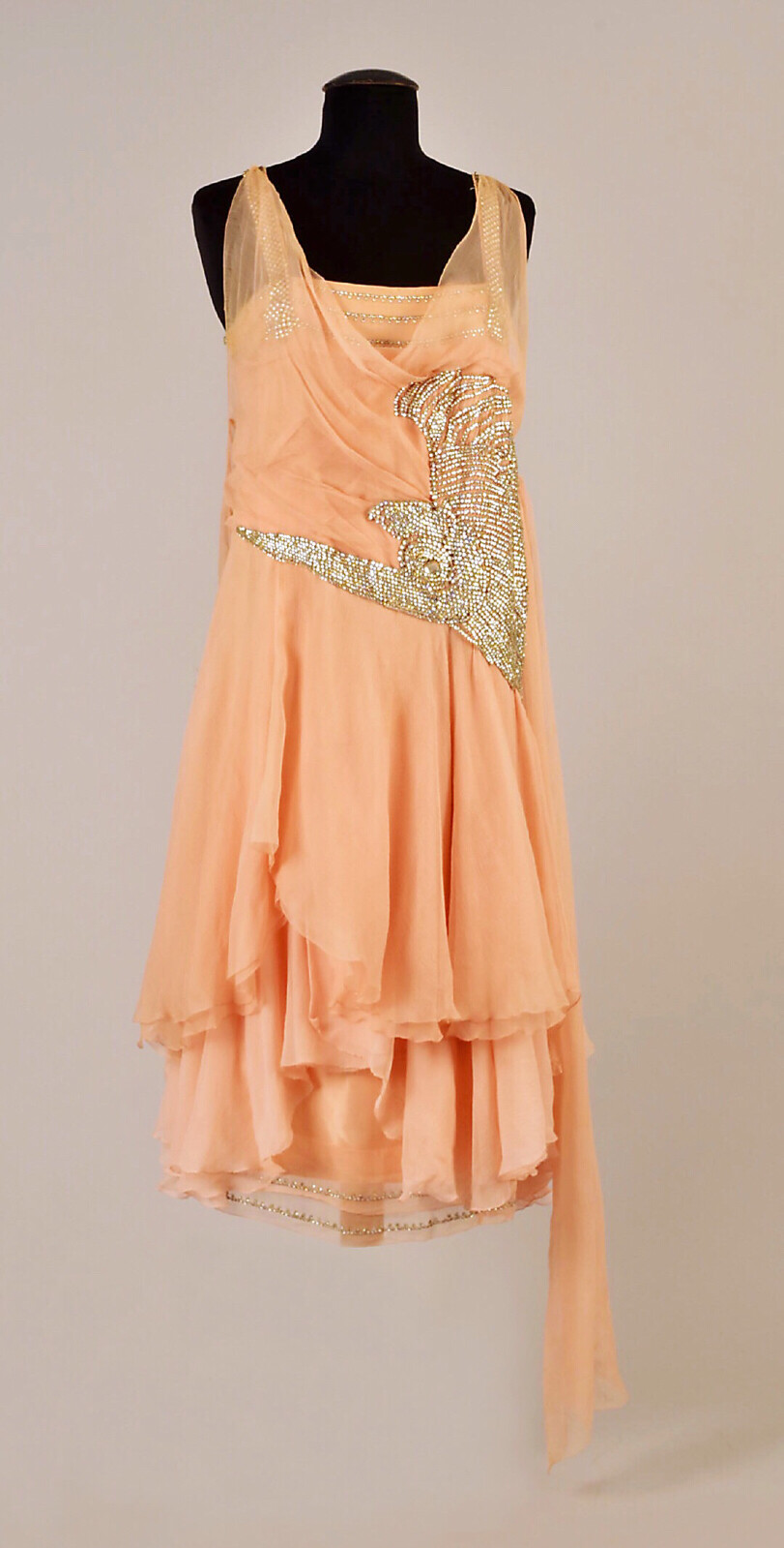 1927 轻盈的粉色雪纺晚礼服,不规则裙摆多层叠落,单独垂下一条长飘带