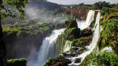 伊瓜苏河蜿蜒穿过两个不同国家的国家公园，上游在巴西，下游则在使用西班牙语的阿根廷。一道蔚为壮观的景致将河流的上下游分开，并标志着两个南美国家之间的边界：伊瓜苏瀑布从巴拉那高原边缘倾泻而下，形成约 275 …