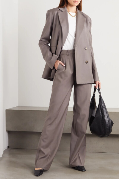 LOULOU STUDIO 创始人 Chloé Harrouche 将品牌服饰定位为“经典款式和优质工艺的结合”。这款 “Tatakoto” 西装外套以灰色羊毛精裁而成，呈传统的双排扣廓形，微垫肩设计使造型更加立体。不妨搭配精裁的长裤或短裤…