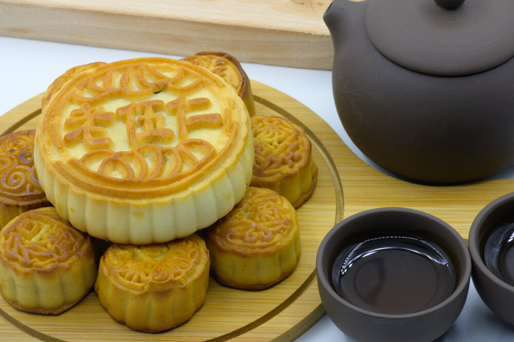 月饼 月团 小饼 丰收饼 团圆饼 甜的 面点 馅料 中式糕点 中式点心 中秋节 中国节日 传统节日 八月十五 农历 团圆 赏月 烤 烘焙 甜点 食物 食品 美食 美味 中国文化 膳食 饮食 点心 中国食品 文字 圆形 样式 白色背景 木托盘 托盘 茶壶 茶杯 紫砂壶 茶水 绿色 植物 月饼模具 模子
