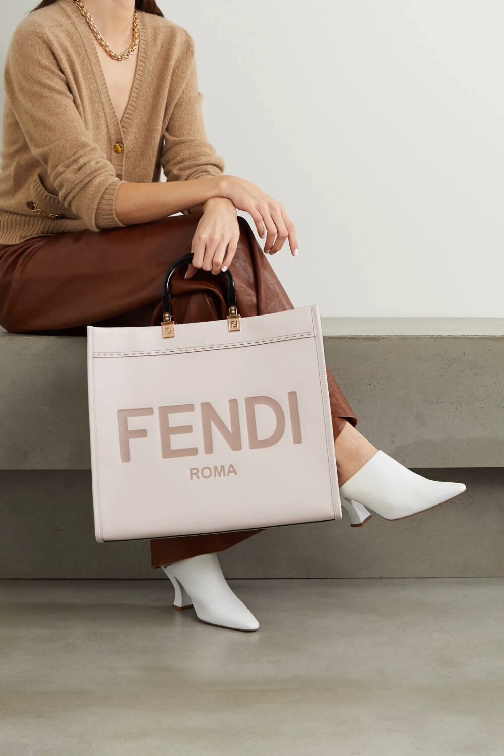 Fendi 这款 “Sunshine Shopper” 手提包以皮革于品牌意大利工坊中制成，饰有别致醒目的 Logo 压花，仿玳瑁纹手柄上缀有低调的金色 “FF” 标志。包身容量充裕，足以为你妥善收纳笔记本电脑和备用高跟鞋等日常必备物品。