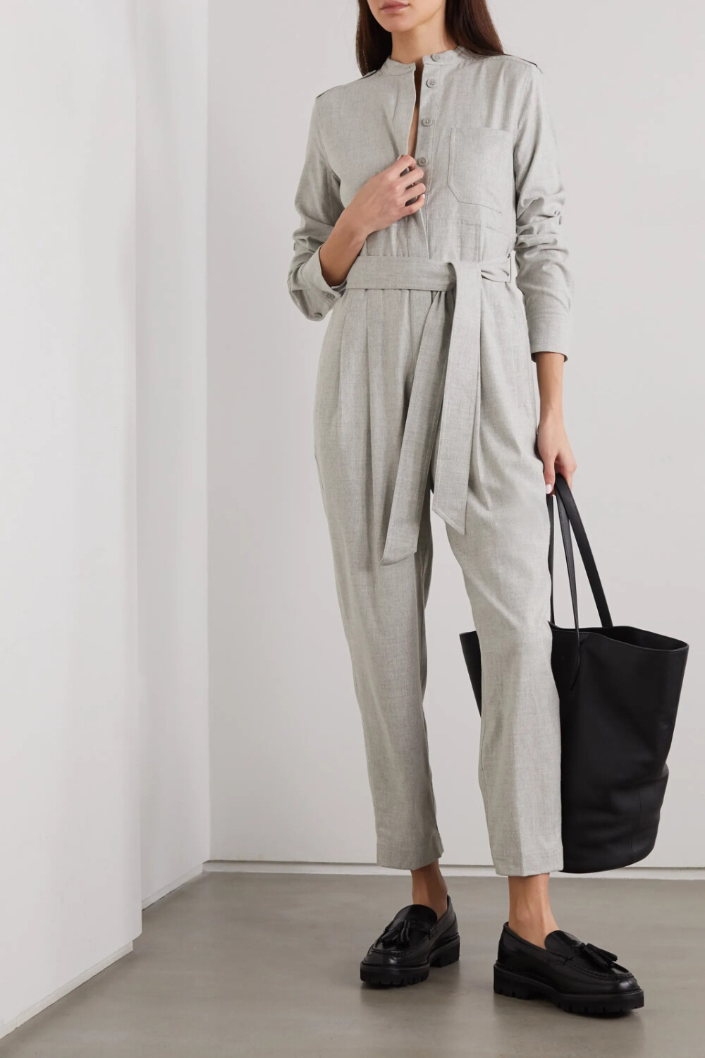 EQUIPMENT 这款 “Leondrea” 梭织连身裤风格极简，彰显出鲜明的工装风范。单品剪裁宽松，正面采用纽扣设计，同色系腰带可用于收束腰身。灰色调的它与黑色踝靴尤其相衬。