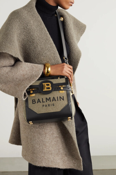 Balmain 的 “B-Buzz” 系列包袋因正面的超大金色 “B” 字五金配件而自带超高辨识度，这款单肩包正是出自其中。单品采用军绿色帆布于意大利打造而成，侧面所饰铆钉让你可随心调整包型，轻松收纳各式必备小物。建议…