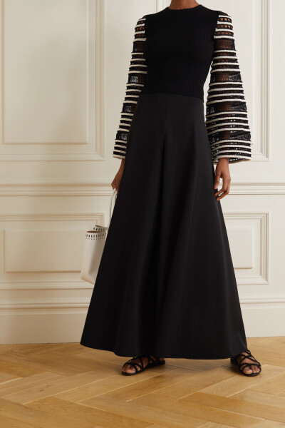 Alaïa 这款上衣采用罗纹棉质混纺面料制成贴身样式,精美钟形袖所用的 “Vienne” 镂空针织图案在同品牌包袋上也有体现——这一繁复纹样取材于创始人 Alaïa Azzedine 祖国突尼斯的建筑。不妨将它的下摆束入超长半身裙…