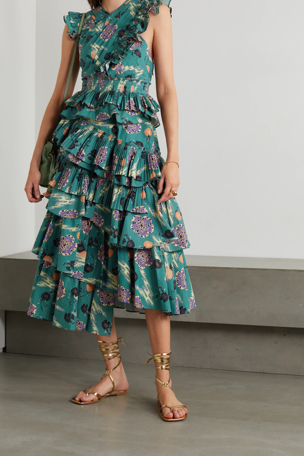 Ulla Johnson 从和风艺术汲取灵感，创作出 2021 春夏系列。这款 “Aurore” 连衣裙上的折纸风褶裥和精美荷叶边即是其中的典范设计元素。它采用 “River Blossom” 印花纯棉府绸制成，上身呈交叉样式，分层式裙摆丰盈立体。建议与细带凉鞋搭配。