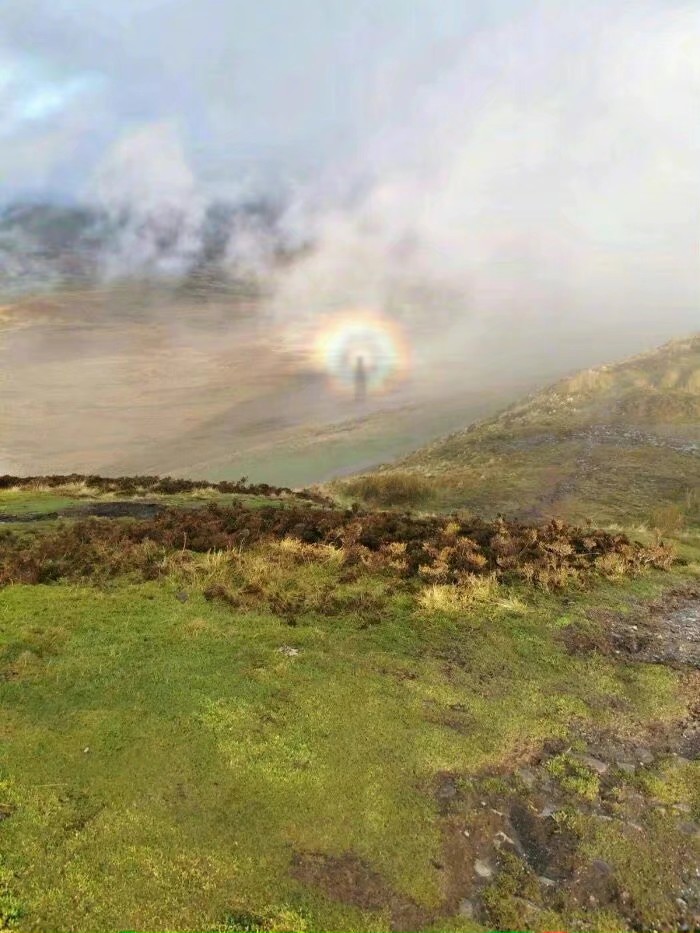 ：——
Reddit网友拍摄到的“布罗肯幽灵（Brocken Spectre）”现象
-
这是一种阳光透过云雾，经由云雾中的水滴发生衍射与干涉，最终形成一圈彩虹光环的光学现象，在光环中经常包括观察者本身的阴影。“布罗肯幽灵”这一名称来源于早期登山者在德国中部哈尔茨山脉最高峰布罗肯山见到的巨大光环。德国科学家约翰·斯伯奇莱克在1780年第一次记录到这一现象，并称之为“布罗肯虹”，此后该地区又出现了多次这种现象。