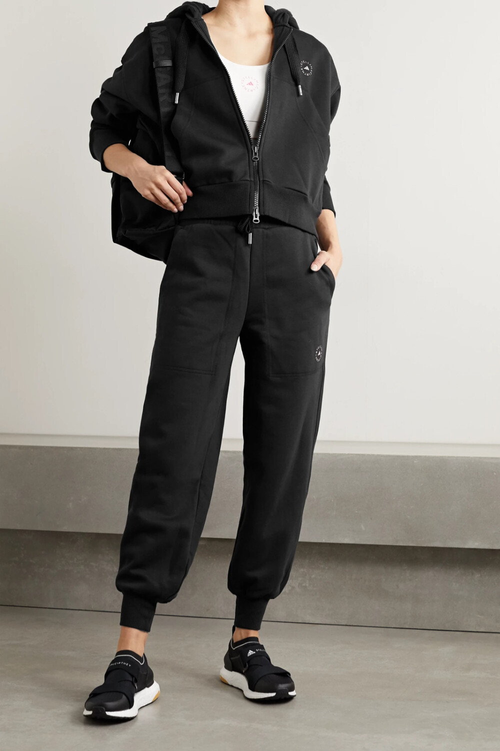adidas by Stella McCartney 这款运动裤采用背衬抓绒的棉质混纺平纹布制成，裤身印有品牌 Logo。它的腰部设有抽绳，松垮裤腿在裤脚处收束。建议与配套帽衫同穿。
