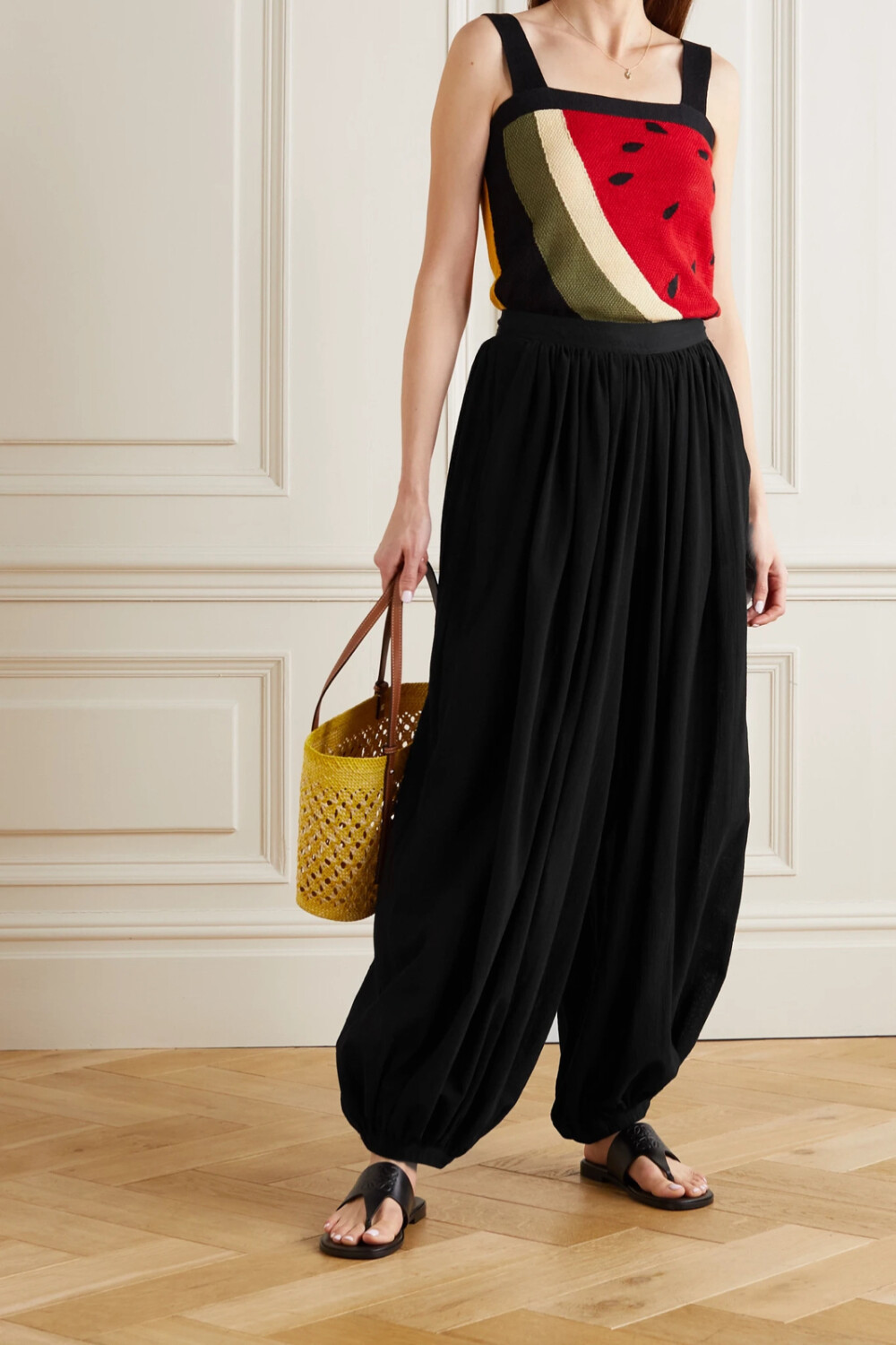 Loewe 这款长裤出自品牌与 Paula's Ibiza 的合作系列，灵感源自 70年代在巴利阿里群岛度假的社会名流，演绎出他们那一份独有的随性优雅。单品垂感优美，裁自轻盈的纯棉巴里纱，缩褶裤脚令灯笼裤身更显丰盈饱满。