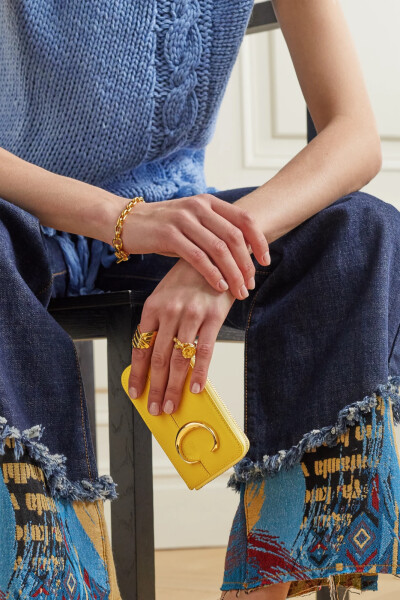 自从 Chloé 的 “C” 包袋系列问世以来，便因简约迷人的金色圈环装饰而备受欢迎，迅速袭卷街头时尚圈。这款卡夹同样带有这一品牌标志元素，令人爱不释手。单品以光滑的皮革制成，采用方便的全拉链开合设计，背面设有…