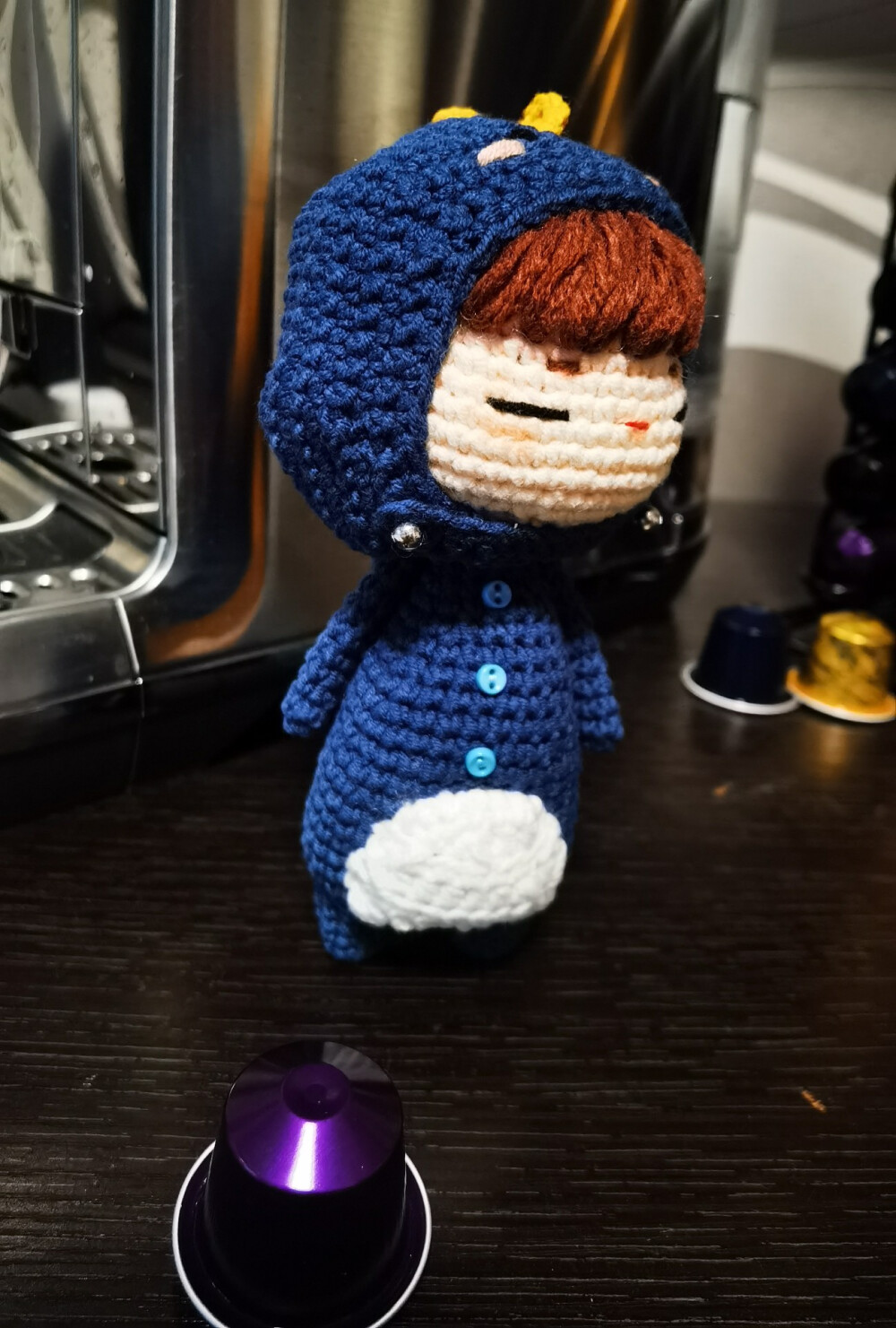 复古蓝+胡萝卜橙黄，一只温柔傲娇的小恐龙娃娃，喜欢蹲在咖啡机和黑色电脑旁边。