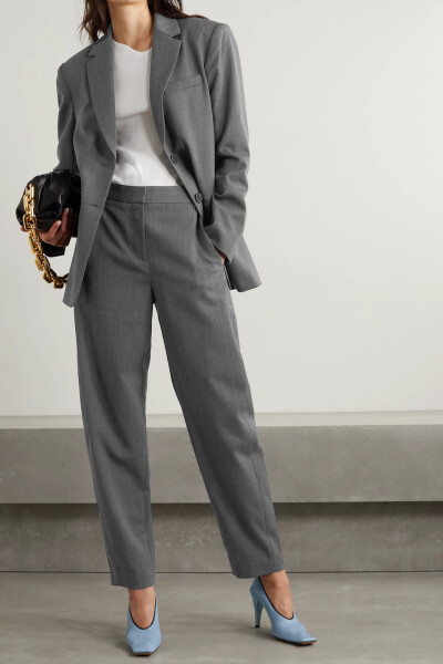 Tibi 这款 “Luka” 锥形裤可与配套西装外套搭成时髦的职场造型，亦可将衬衫束入腰头，踏上乐福鞋，演绎随性优雅。高腰的它裁自含有大量羊毛的斜纹布，呈舒适的灯笼裤造型。深灰的混色裤身百搭实力出众。