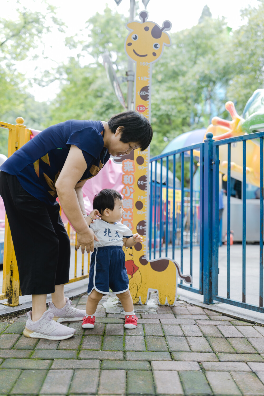 少年宫似乎不太适合你
摄影：洪小漩
出镜：菲比和奶奶
在有孩子之前，我也常去少年宫。主要是贪恋那边的童趣。
不过，我从未办卡消费过。托菲比的福，我办了一张卡，在我虚岁32岁这一年。
我满心欢喜以为菲会兴奋地咯咯直笑。事实上，我失策了。她全程都是一副“陪我妈玩得好累”的样子，多少让我有些受挫。
玩了多个旋转类的游乐设施，我和菲比的奶奶都有些晕乎，几乎快吐了。可是菲比还是一副面无表情的样子。这让我发现，我除了感动自己，简直一无是处。
我和婆婆最后选择了放弃，任由她在少年宫闲庭信步。然后，我们意外发现，她喜欢一个人漫无目的跑来跑去。她一边蹒跚跑步，身边还会有人看着她的衣服逗趣：呦呵，北