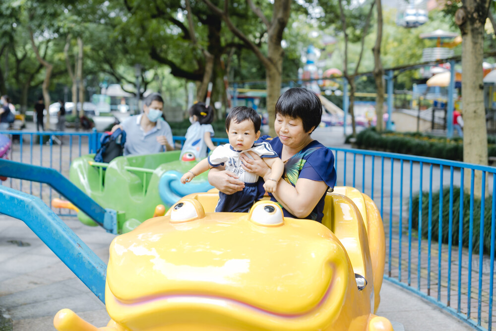 少年宫似乎不太适合你
摄影：洪小漩
出镜：菲比和奶奶
在有孩子之前，我也常去少年宫。主要是贪恋那边的童趣。
不过，我从未办卡消费过。托菲比的福，我办了一张卡，在我虚岁32岁这一年。
我满心欢喜以为菲会兴奋地咯咯直笑。事实上，我失策了。她全程都是一副“陪我妈玩得好累”的样子，多少让我有些受挫。
玩了多个旋转类的游乐设施，我和菲比的奶奶都有些晕乎，几乎快吐了。可是菲比还是一副面无表情的样子。这让我发现，我除了感动自己，简直一无是处。
我和婆婆最后选择了放弃，任由她在少年宫闲庭信步。然后，我们意外发现，她喜欢一个人漫无目的跑来跑去。她一边蹒跚跑步，身边还会有人看着她的衣服逗趣：呦呵，北